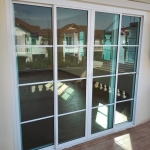 ชุดประตูบานเลื่อนอลูมิเนียมสีขาว กระจกสีเขียวใส พร้อมบานตาย มีแถบคาดบริเวณกระจก