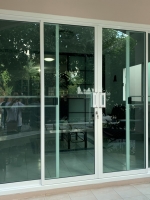 ประตูบานเลื่อนกระจกอลูมิเนียมสีอบขาวกระจกเขียวตัดแสงมือจับใหญ่ตัวล็อคคอม้าแทนประตูบานไม้