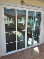 ชุดประตูบานเลื่อนอลูมิเนียมสีขาว กระจกสีเขียวใส พร้อมบานตาย มีแถบคาดบริเวณกระจก