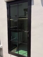 ประตูบานเปิดอลูมิเนียมสีดำกระจกเขียวตัดแสงคาดลายลูกฟักพร้อมมุ้งลวดจีบ