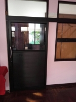 ประตูอลูมิเนียมบานแขวนสีดำครึ่งบานเป็นกระจกและลูกฟูกอลูมิเนียม