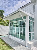 กั้นห้องโถงหน้าบ้านด้วยประตู หน้าต่างบานเลื่อน อลูมิเนียมสีขาวกระจกเขียวตัดแสงพร้อมมุ้งลวด